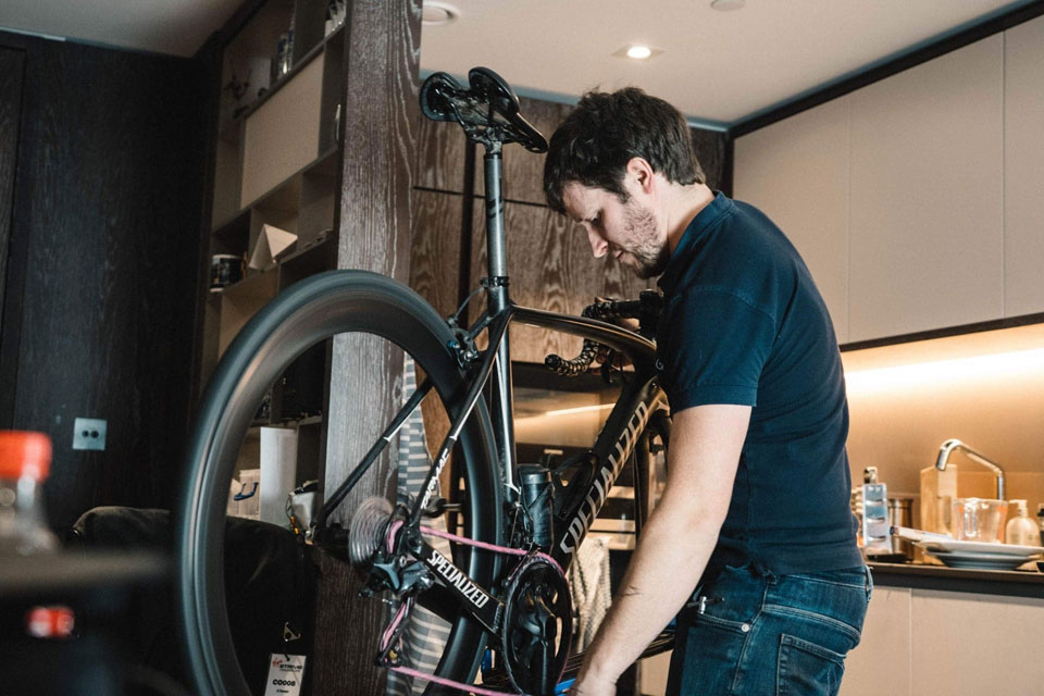 Brown working carefully on a bicycle